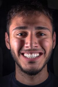un homme souriant à la caméra